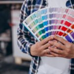 Persona mostrando una guía de colores Pantone para impresión offset, ideal para diseñadores gráficos.