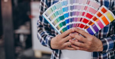 Persona mostrando una guía de colores Pantone para impresión offset, ideal para diseñadores gráficos.